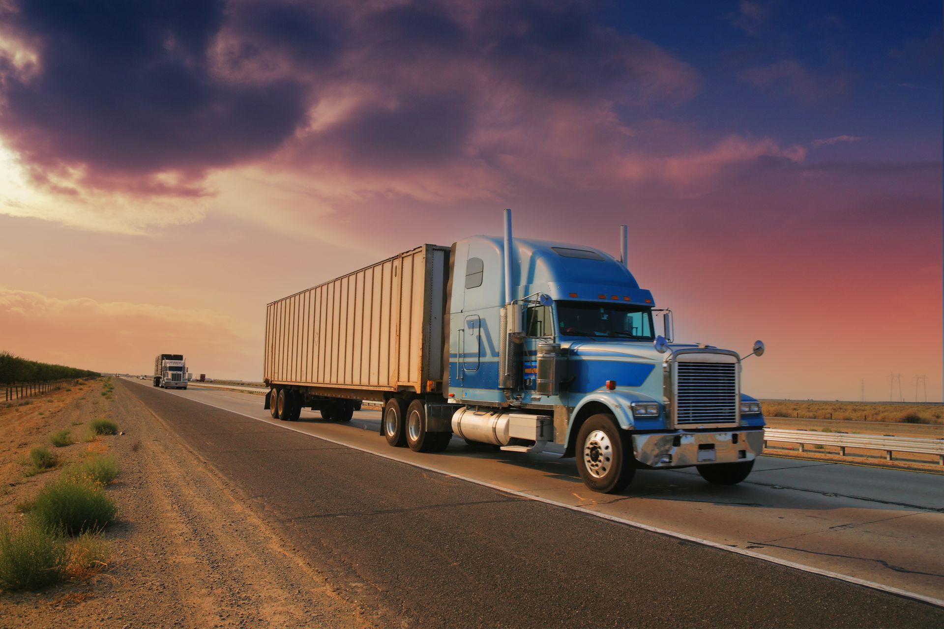 A truck is driving on a desert road at sunset, showcasing reliable commercial truck insurance.