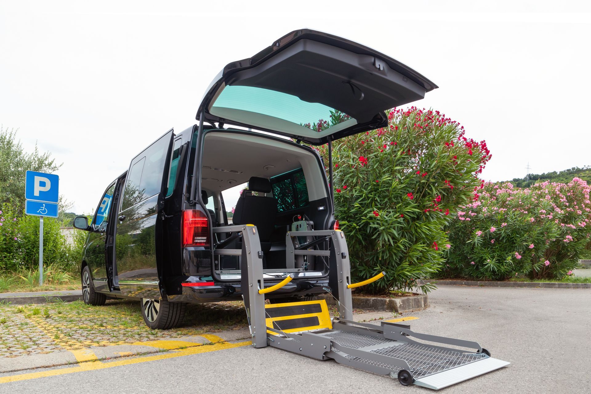 An accessible van with a rear wheelchair ramp deployed in a parking area