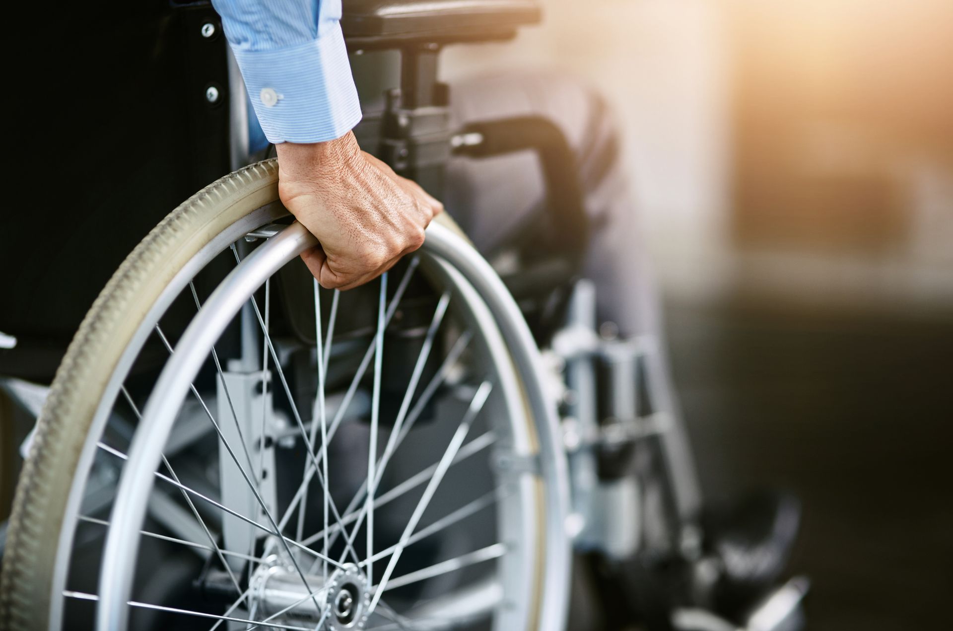 Closeup shot of an unrecognizable man sitting in a wheelchair.
