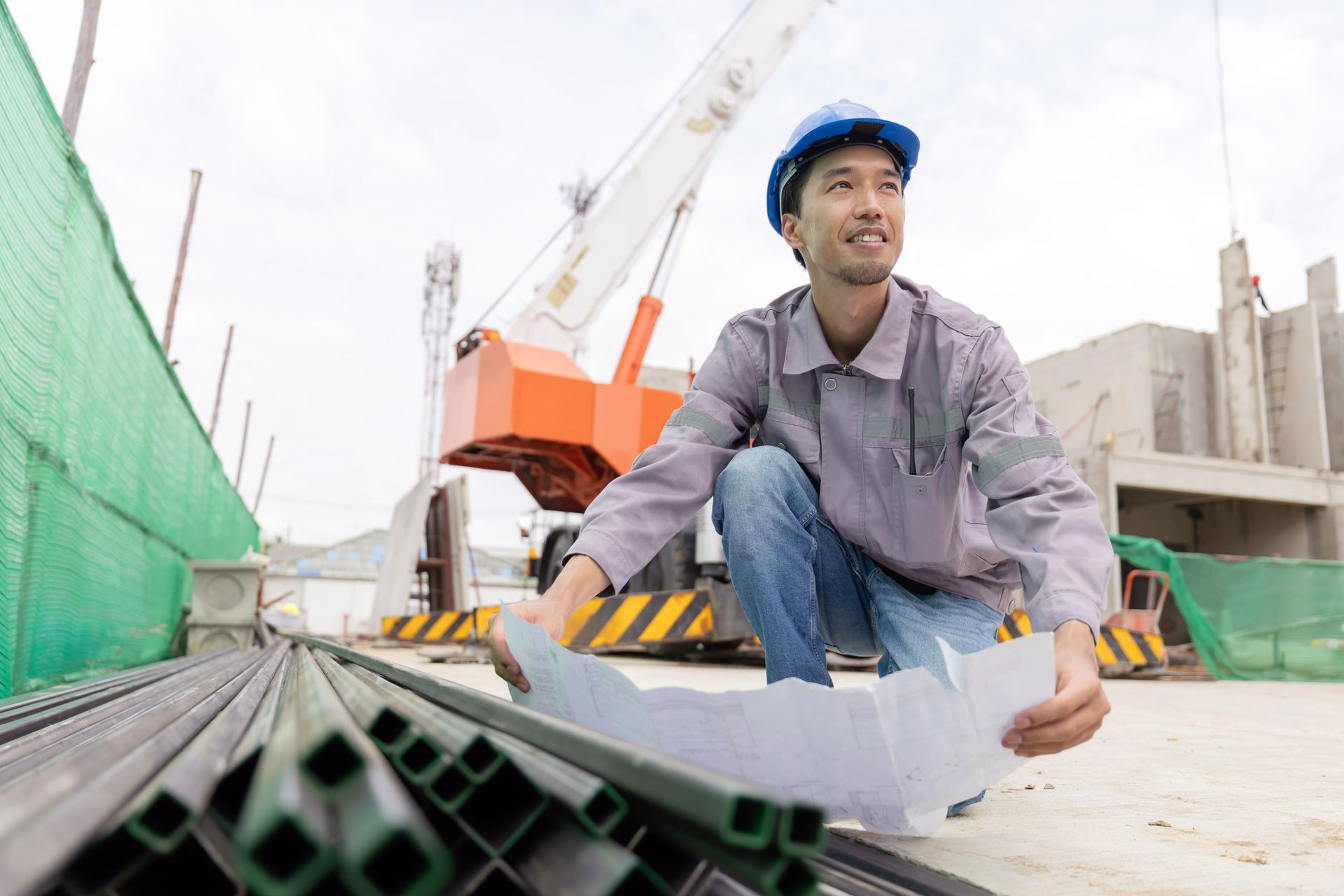 A construction manager in a safety helmet inspects a building site.