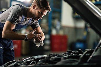 Auto Maintenance — Mechanic Cleaning Hands After Working on Car Engine in San Diego, CA