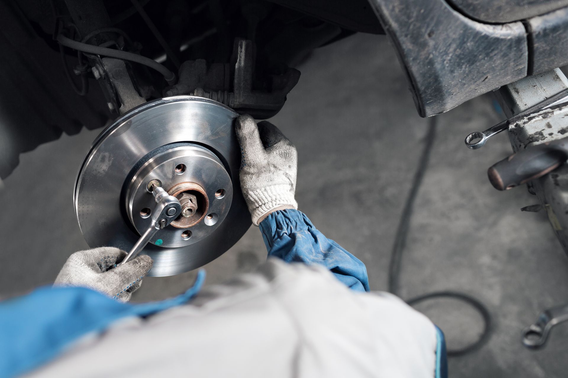 Technician replacing brake rotor for peak performance, part of the BMW services offered by August Eu