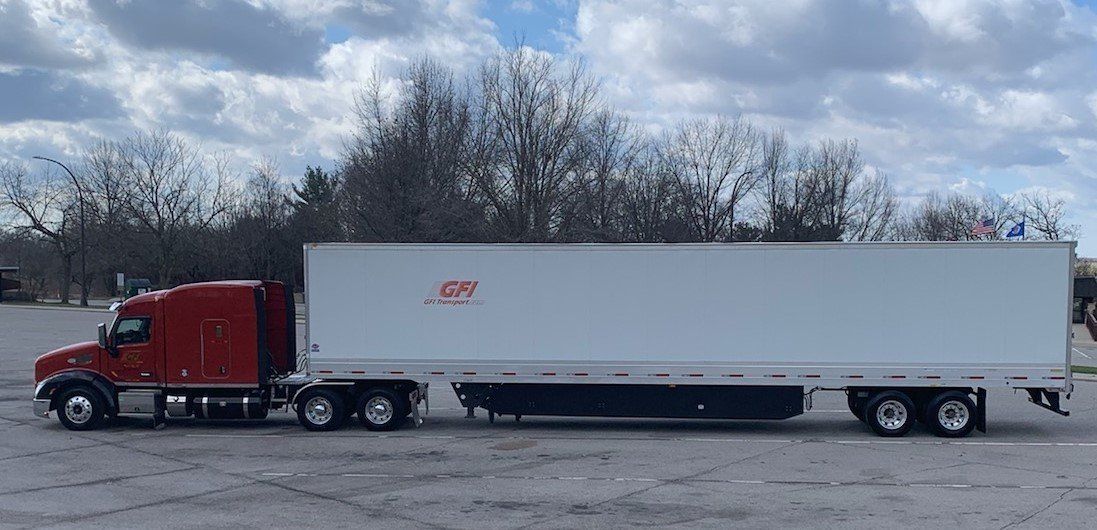 A red semi van trailer is parked on the side of the road of GFI Transport logistics services central PA