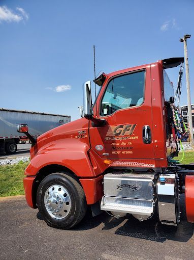 A red GFI Transport semi truck is parked in a parking lot.