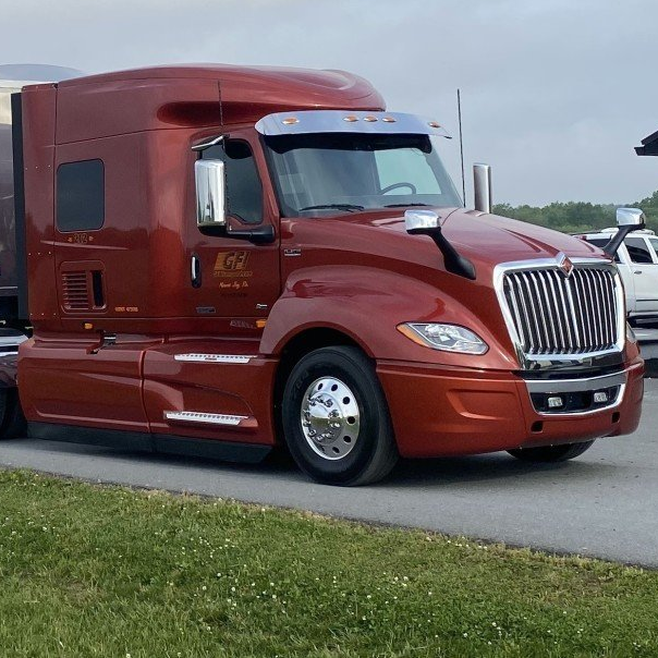 A red semi truck is parked on the side of the road