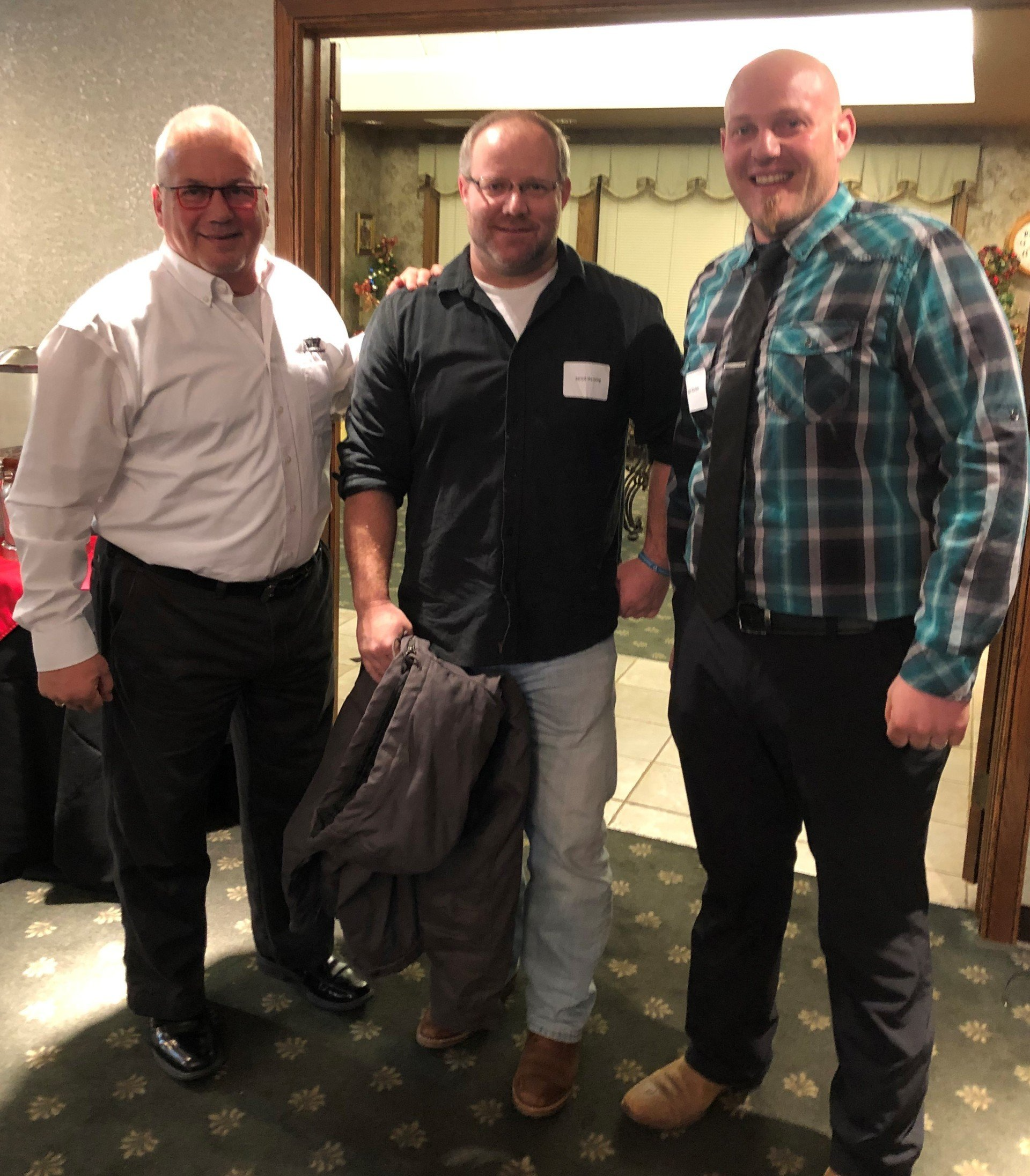 Three men are posing for a picture in a room