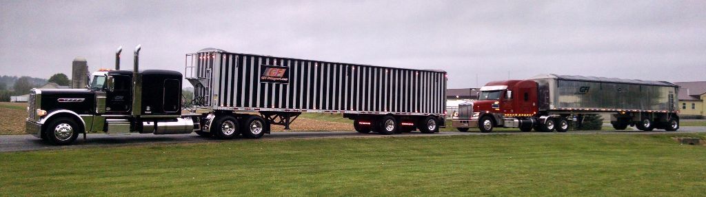 A semi truck is driving down a road with a trailer attached to it from GFI Transport.