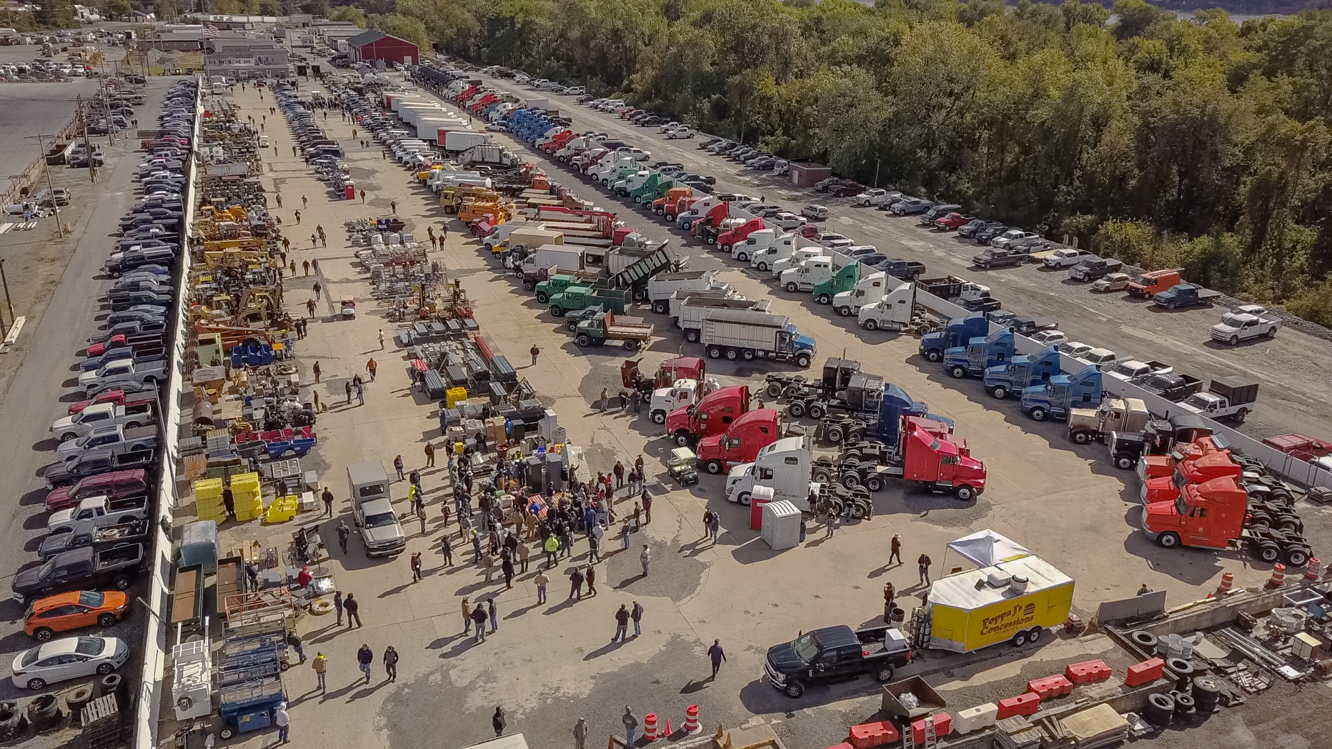 An aerial view of a parking lot filled with lots of trucks and people.