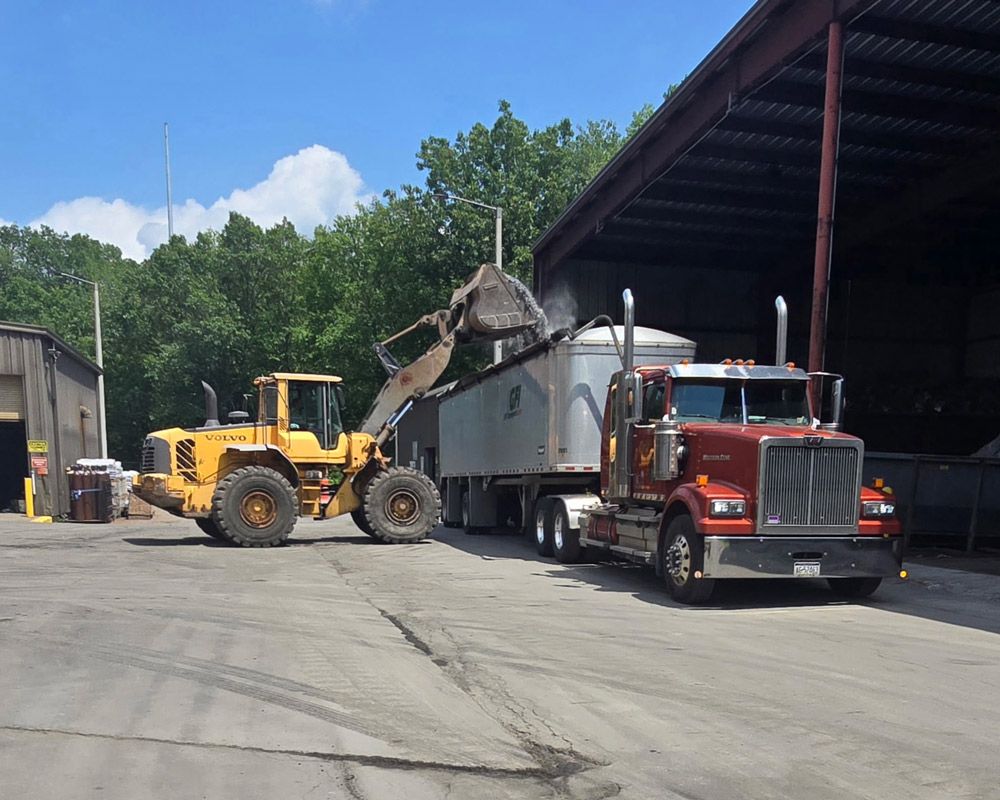 A GFI Transport semi truck is parked and is being loaded with Scrap Metals