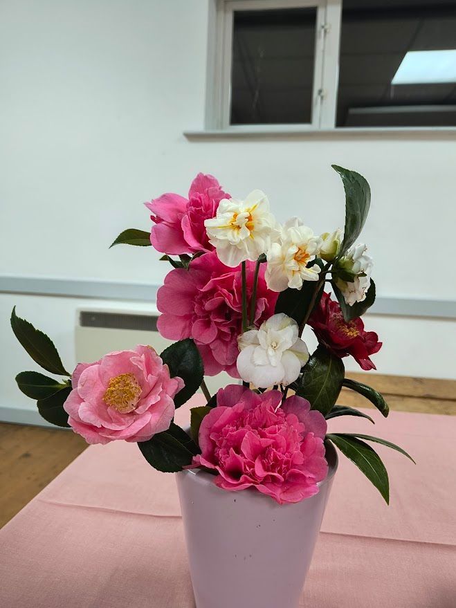 1st prize: Theresa D.  Arrangement in small grey vase with pink and cream flowers, green foliage.