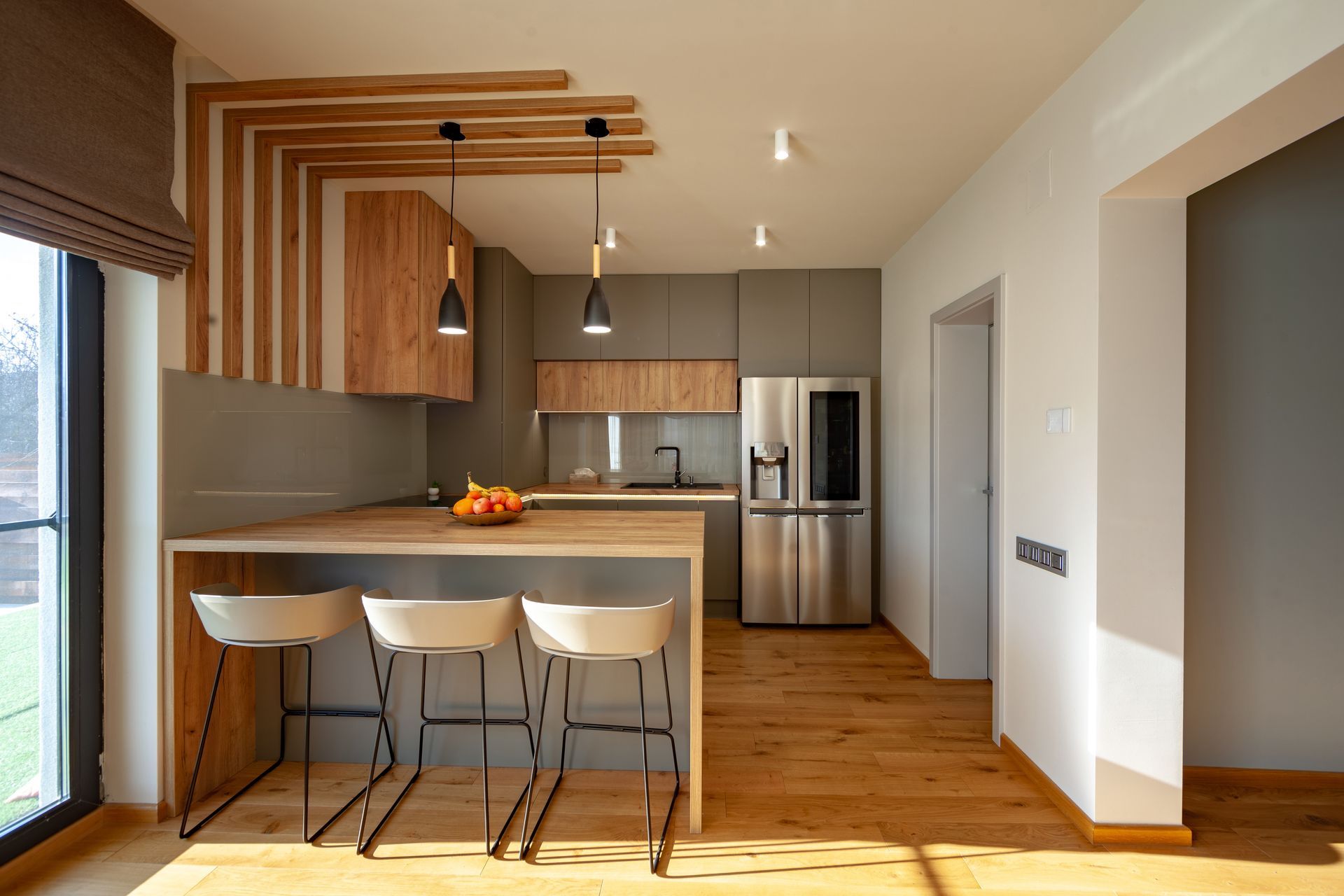 A kitchen with a stainless steel refrigerator and wooden cabinets