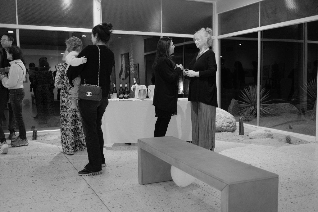 A group of people are standing around a bench in a room.