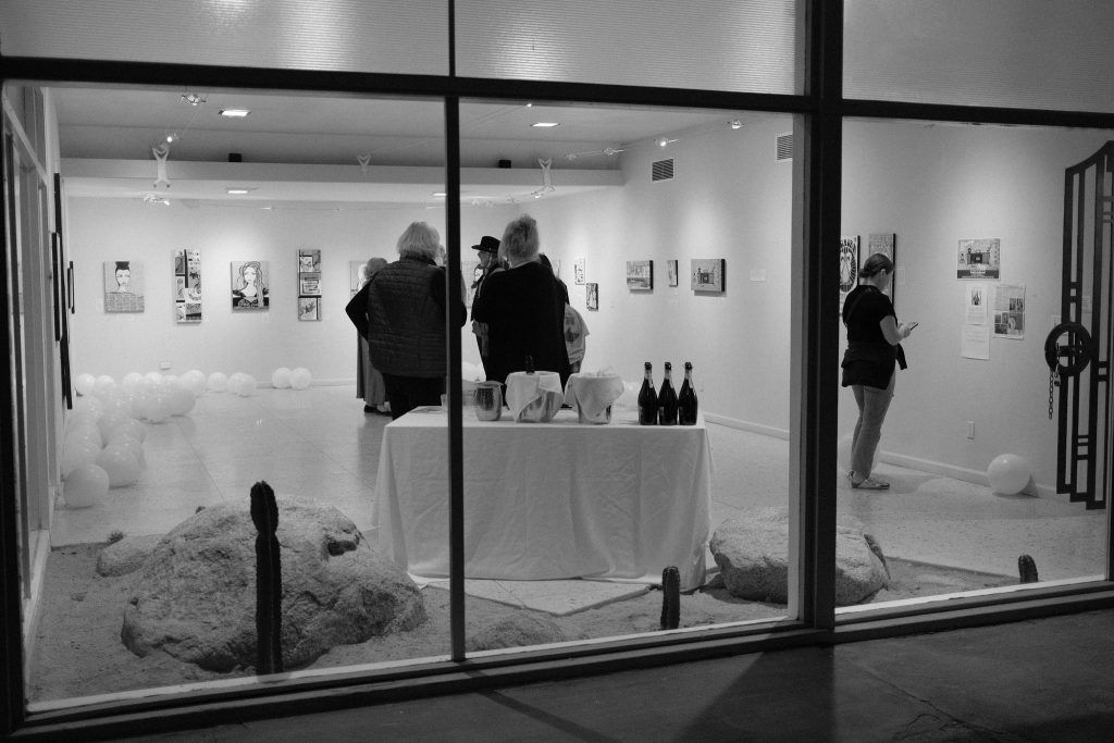 A black and white photo of people in a gallery