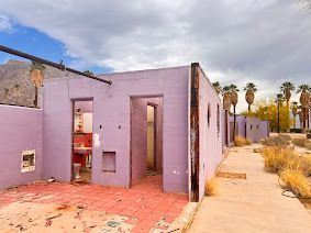 A purple building with a bathroom and a walkway in front of it.