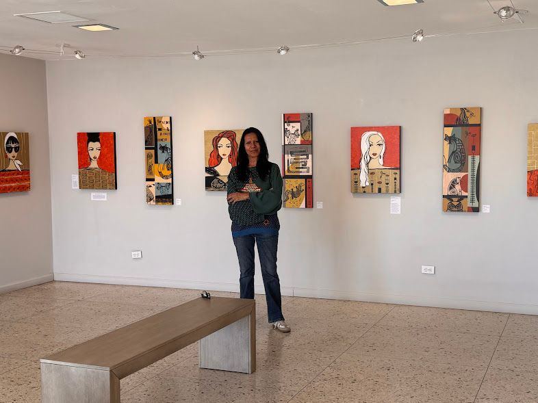A woman is standing in a room with paintings on the wall