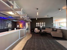 A hotel lobby with a couch , chairs , and a counter.
