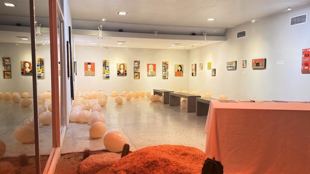 A room filled with lots of balloons and paintings on the wall.
