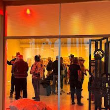 A group of people are standing in front of a glass door in a room.