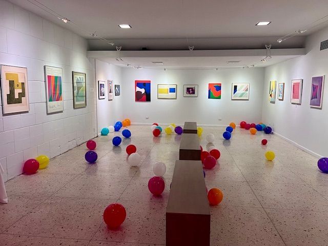 A woman is standing in a room with paintings on the wall