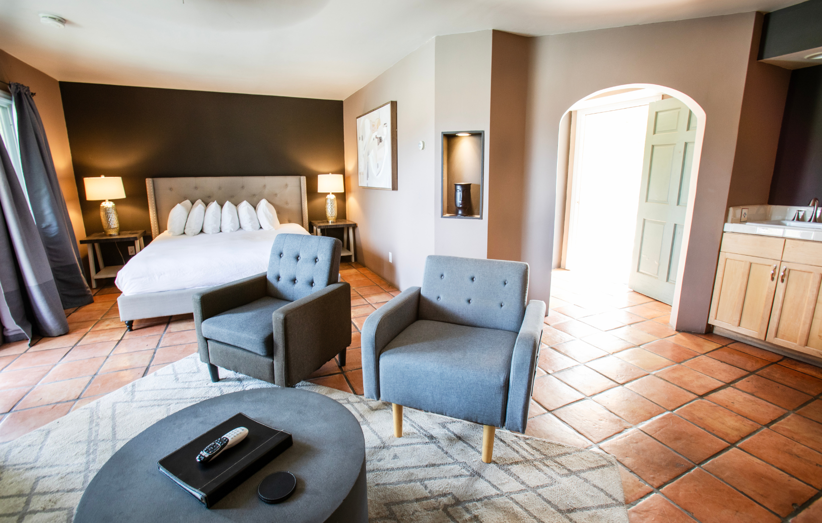 A bedroom with a king size bed , two chairs and a coffee table.