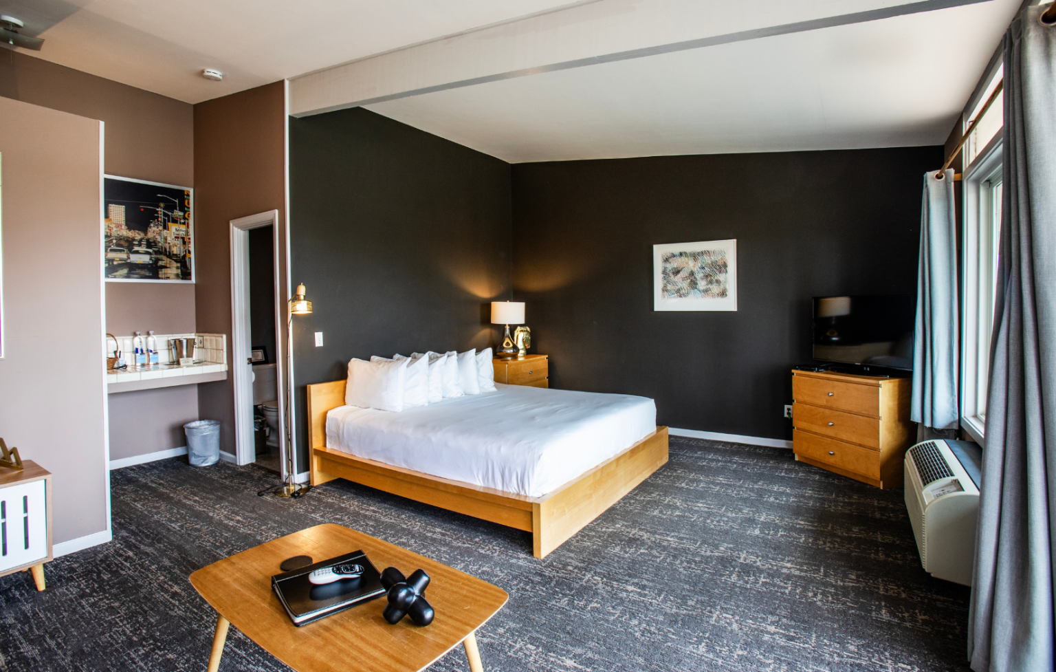 A hotel room with a king size bed and a coffee table.