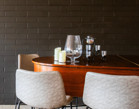 Two chairs are sitting at a table with candles on it.