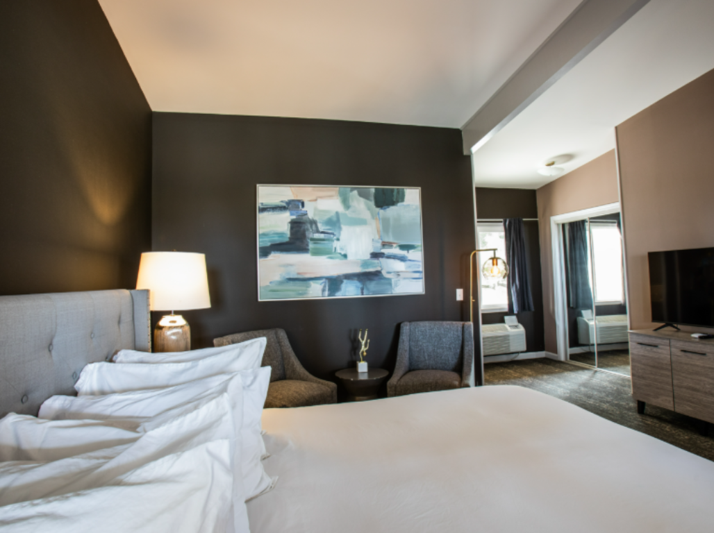 A hotel room with a large bed and a painting on the wall