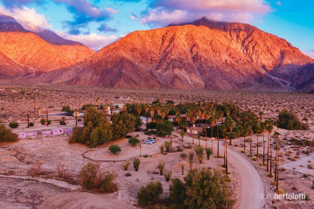 An aerial view of a desert landscape with mountains in the background.