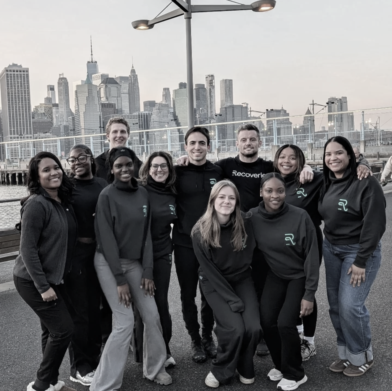A group of people posing for a picture in front of a city skyline