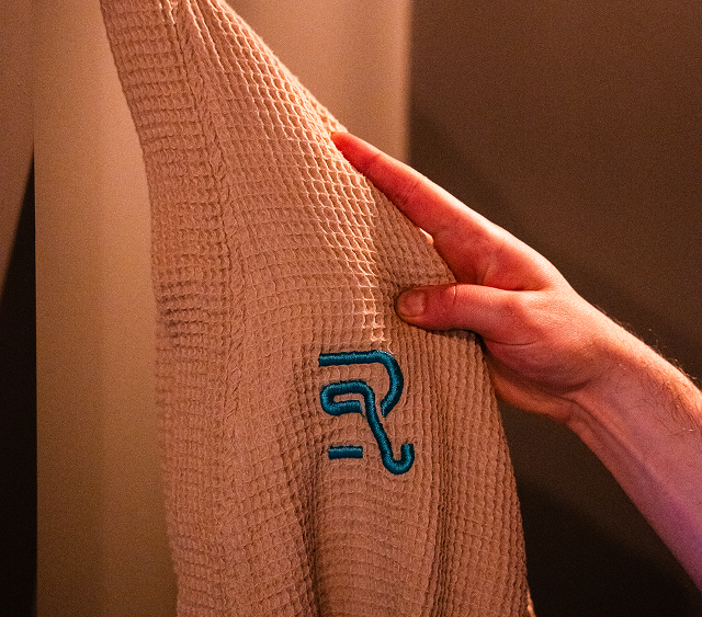 A person is touching a robe with the letter r on it