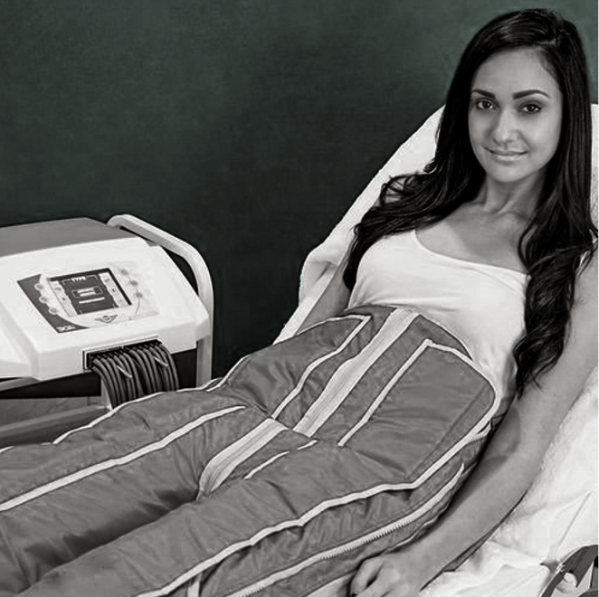 A woman is laying on a bed with a machine in the background