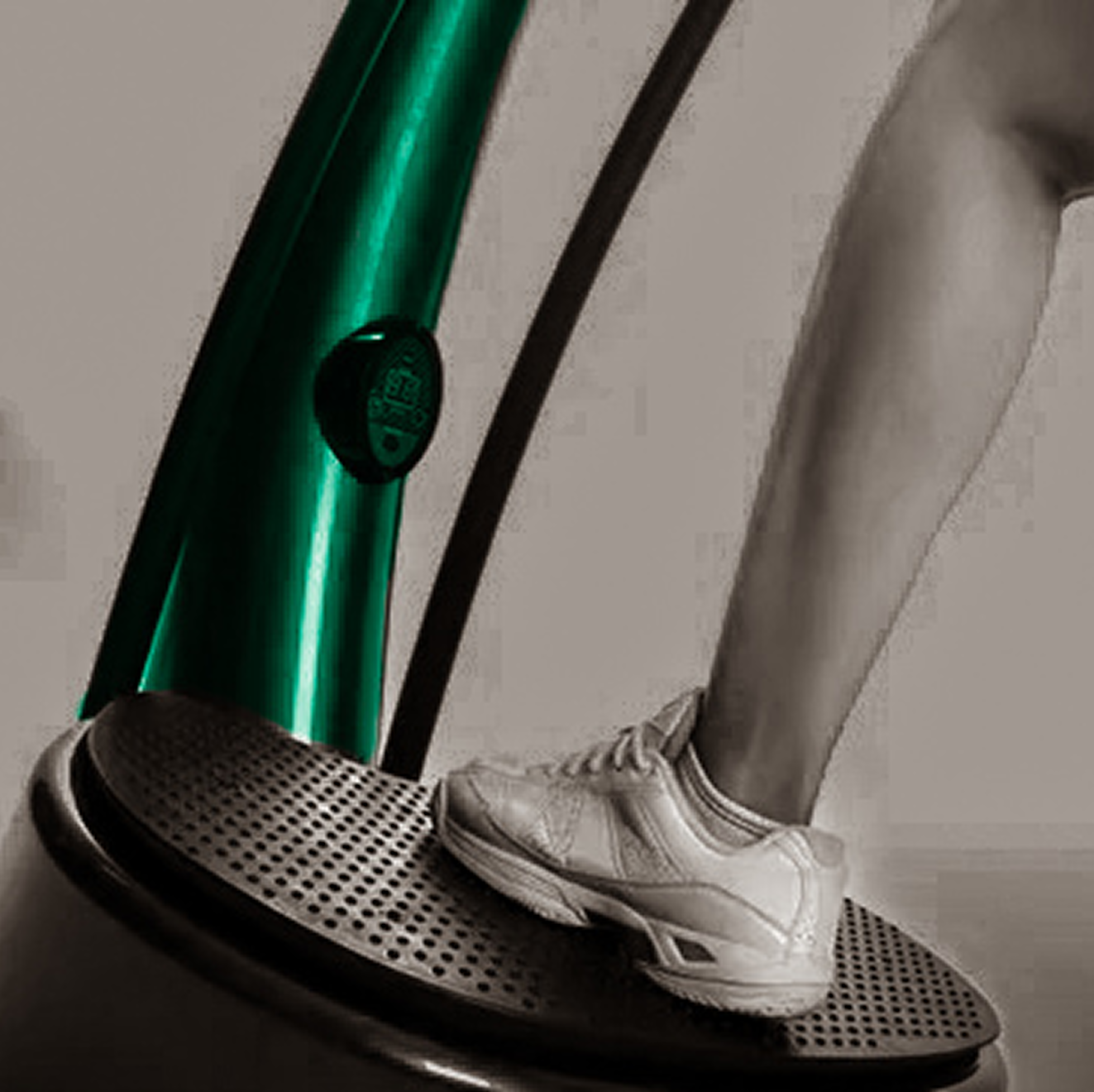 A person is standing on a vibration machine with a green pole in the background.