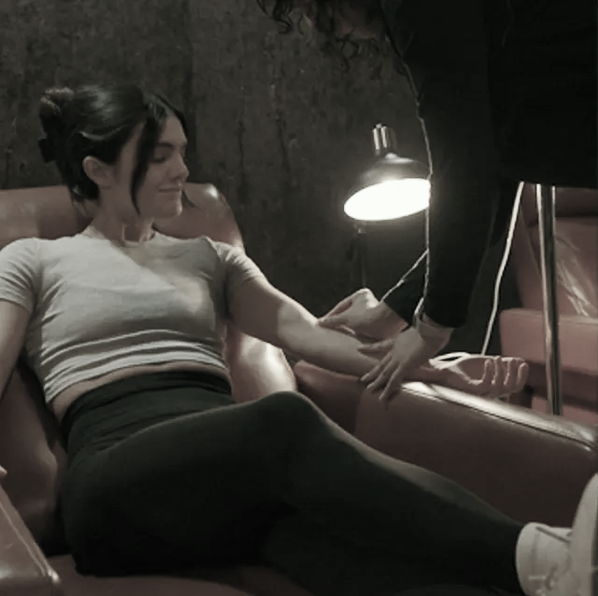 A woman is sitting on a couch with her legs crossed