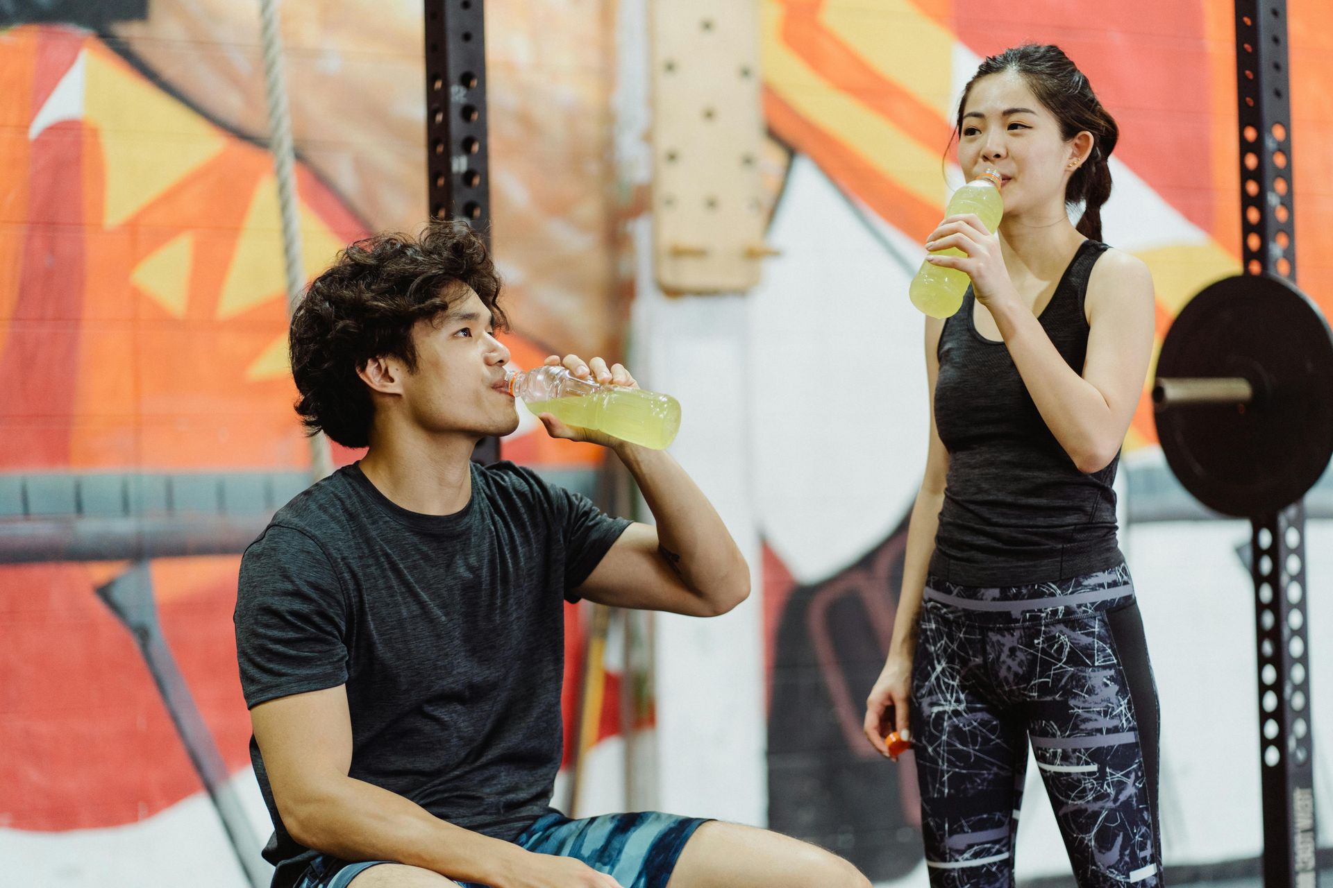 Two  people drinking fluids after a workout