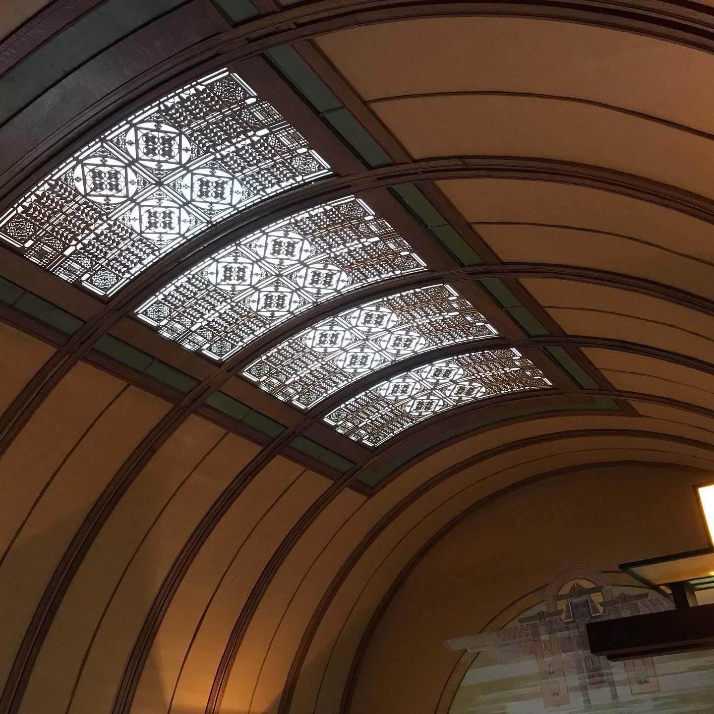 Arched ceiling with geometric skylights, brown and cream tones.