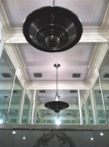 Ornate ceiling with two pendant lights reflected in mirrored walls.