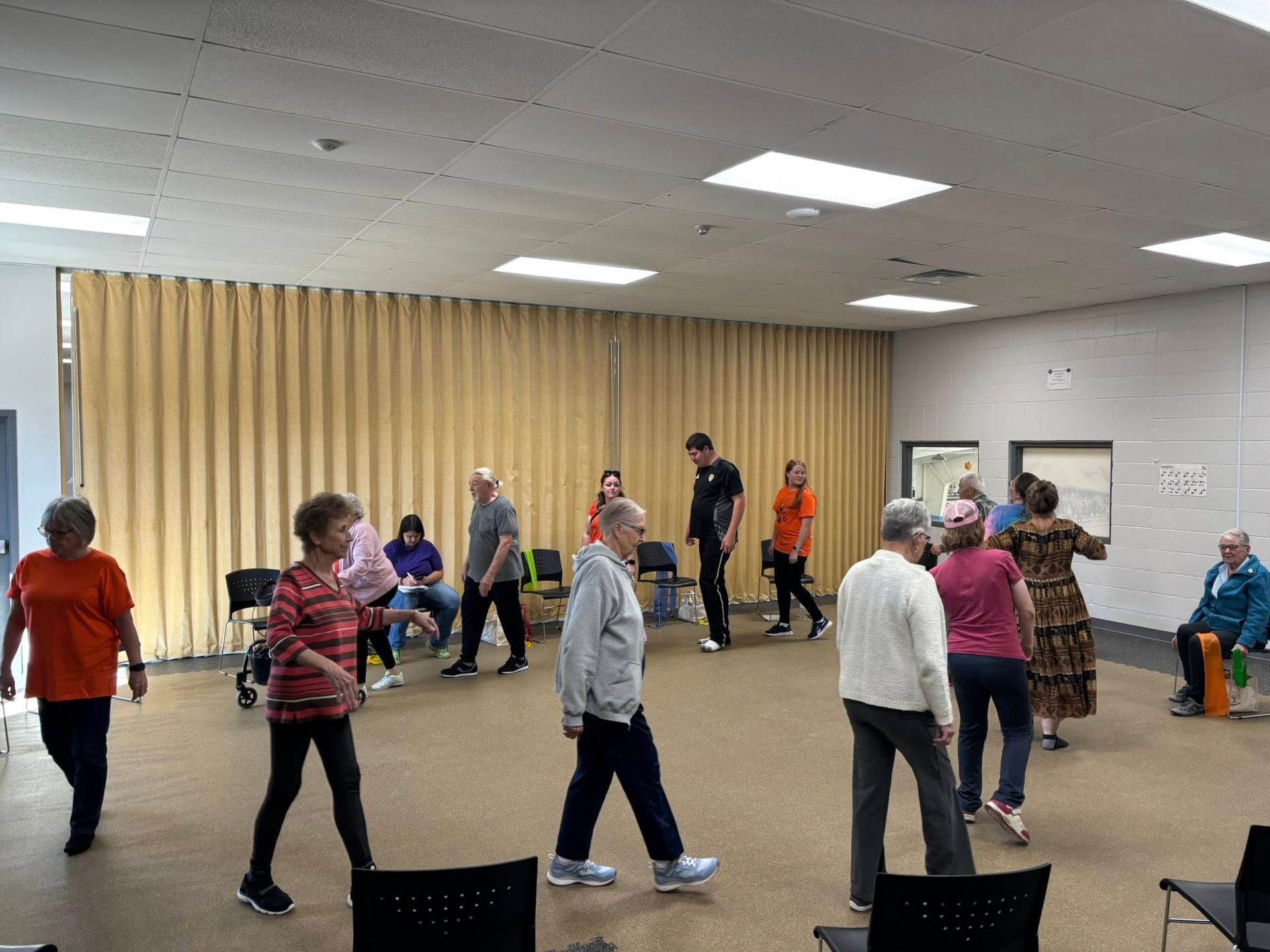 Two women wearing masks are holding a large check in a store.