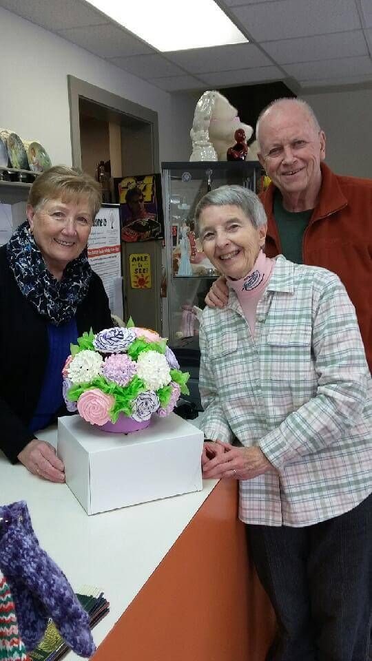Two women and a man are posing for a picture in a store.