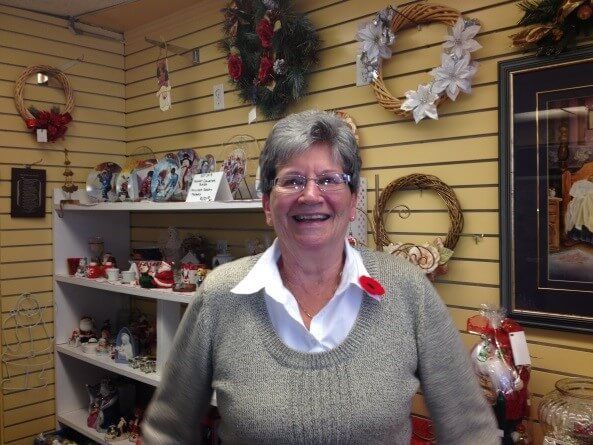 A woman wearing glasses is smiling in a store