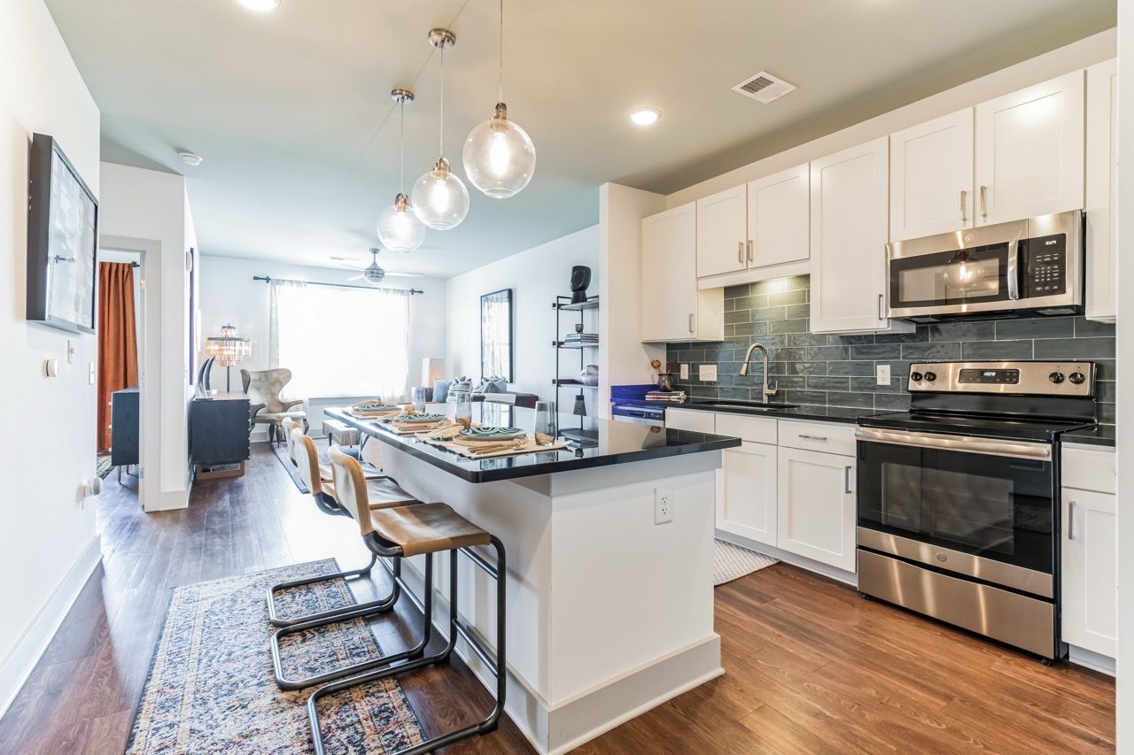 Open-concept kitchen with island, white cabinets, and stainless appliances.