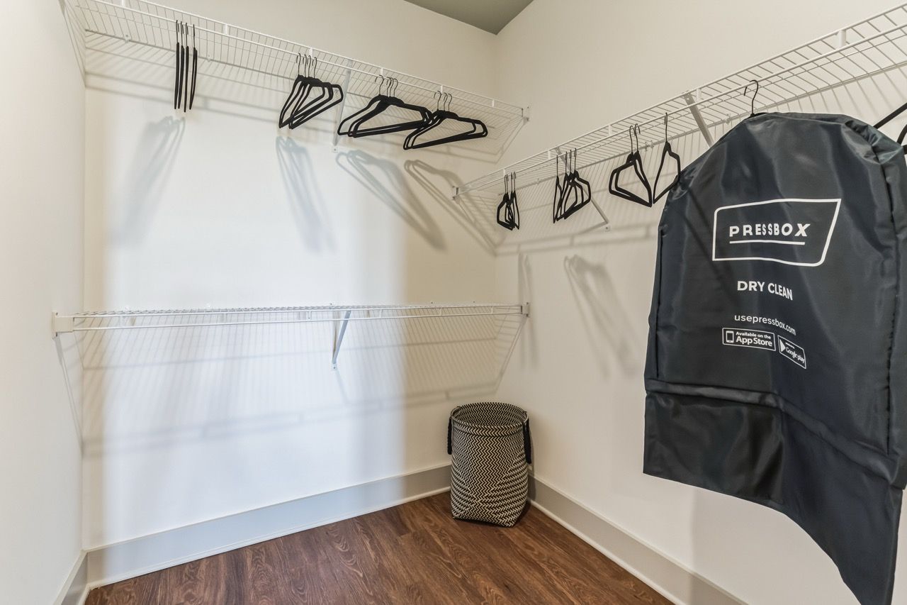 Walk-in closet with wire shelving, hangers, a garment bag, and a storage basket.