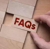 A hand places a wooden block with the red letters 