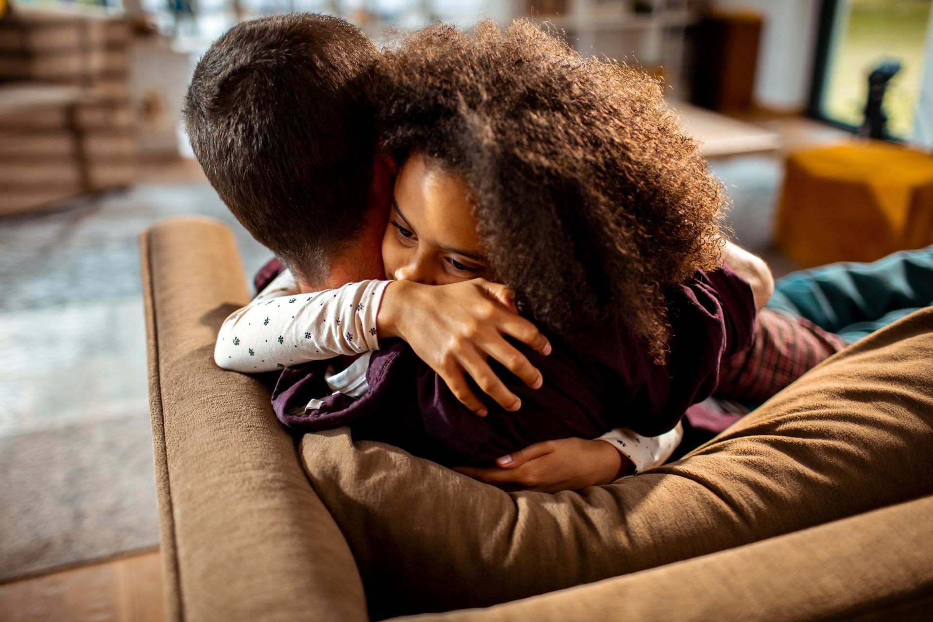 Person hugging another on a couch