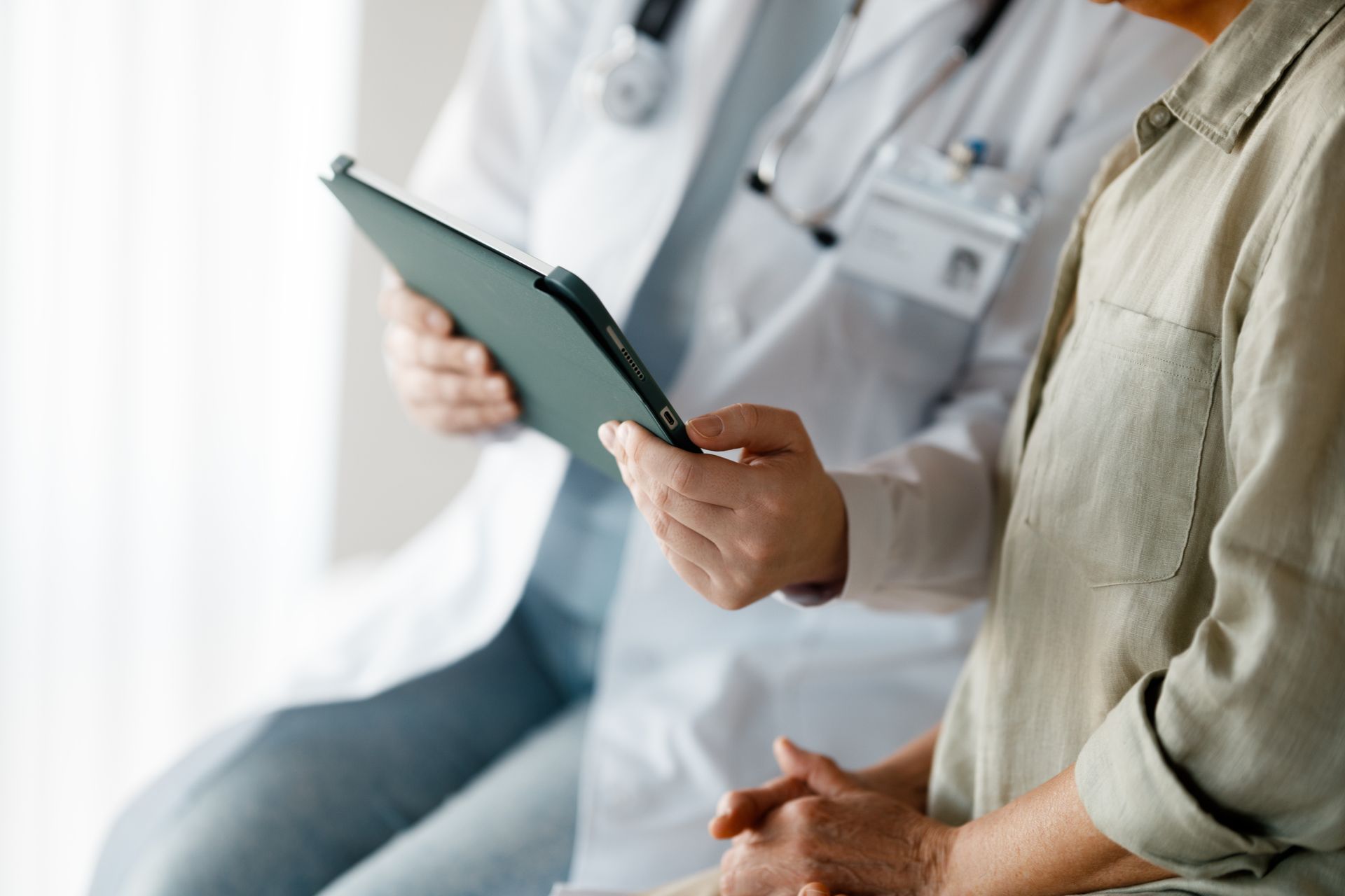 Doctor in white coat reviewing medical records with a patien.