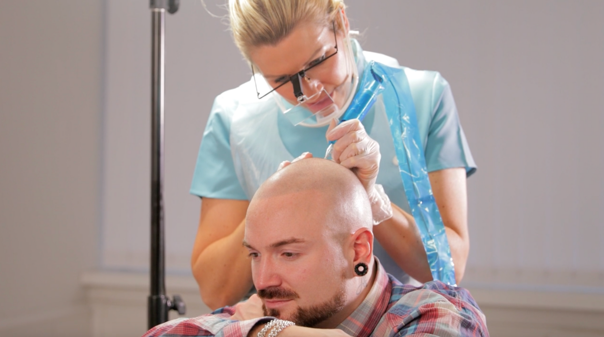 A woman is cutting a man 's hair in a salon.