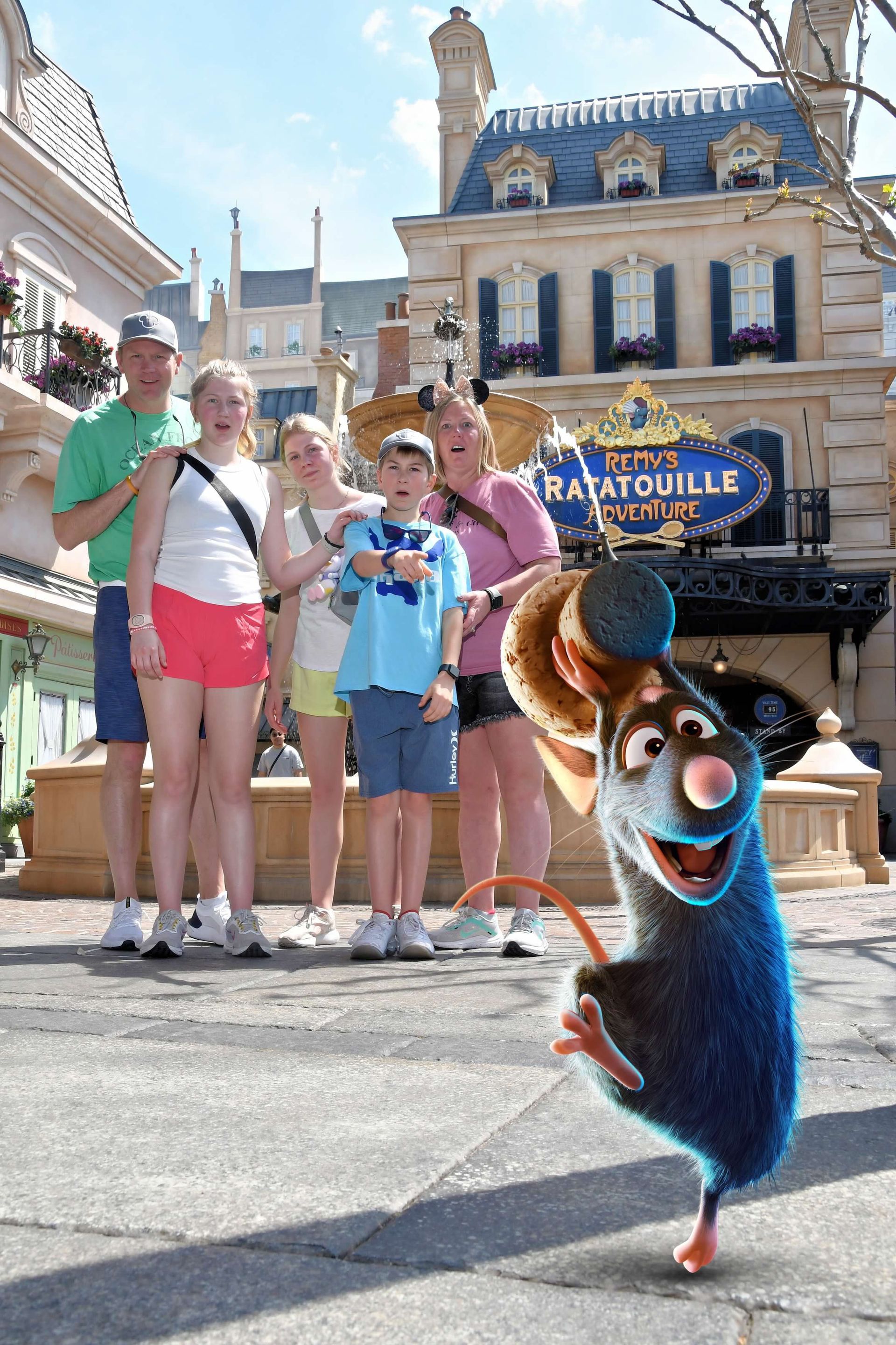 A group of people standing in front of a building that says ratatouille at Disney World