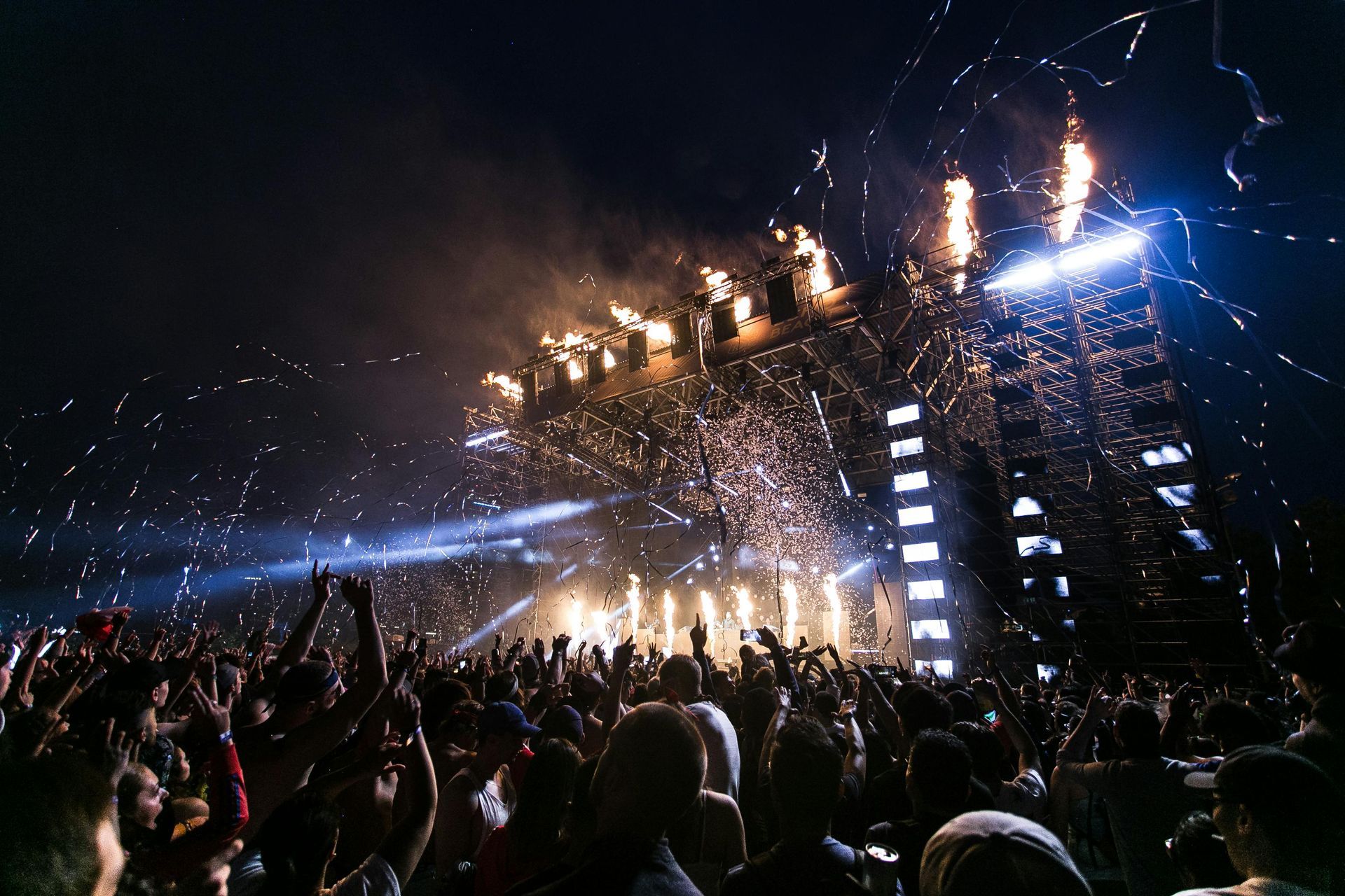 A crowd of people are standing in front of a stage at a concert in Chicago. 