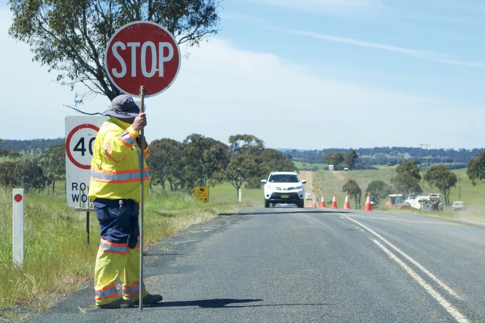 Worker Holding Stop Sign — Comprehensive Traffic Management in Hunter Region, NSW