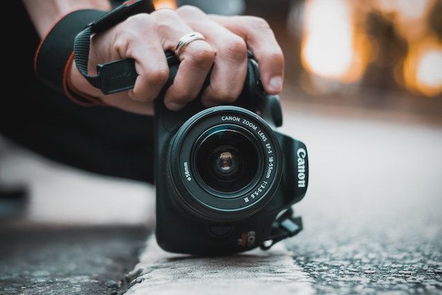 man taking a photo with the canon eos rebel t100