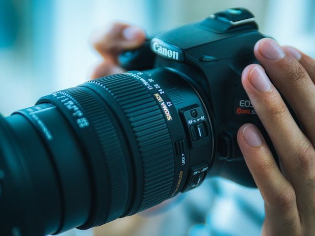 man holding canon eos rebel sl3